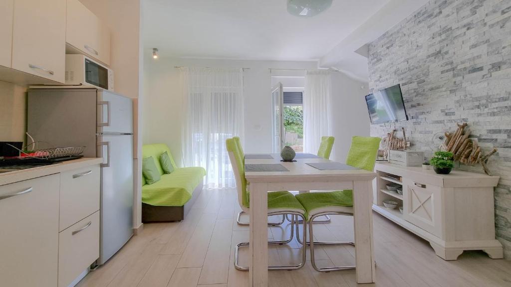 a kitchen with a table and green chairs in a room at Sebastian in Novigrad Istria