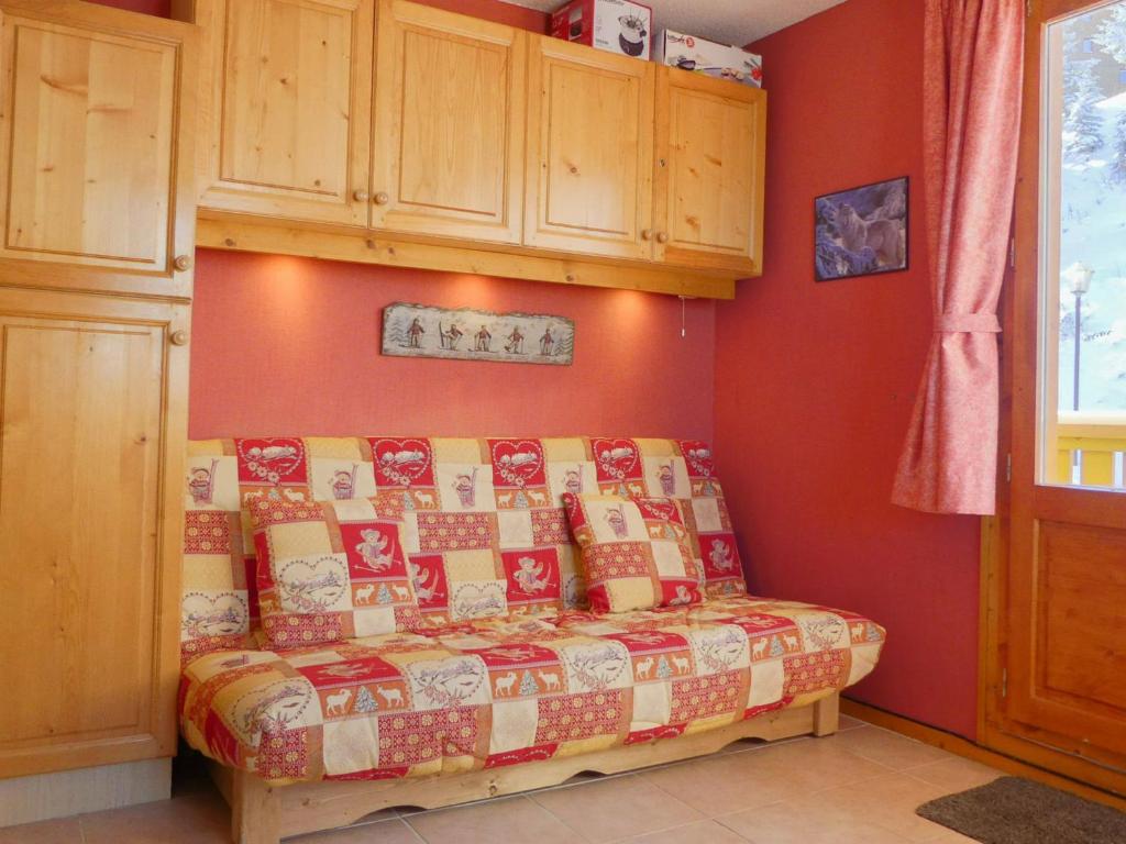 メリベルにあるAppartement Méribel, 3 pièces, 6 personnes - FR-1-182-181の赤い壁のドミトリールームのベッド1台分です。