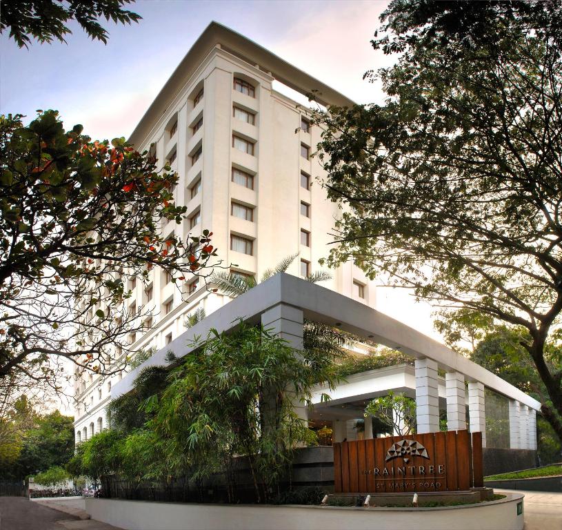 un gran edificio blanco con árboles delante de él en The Raintree, St. Mary’s Road en Chennai