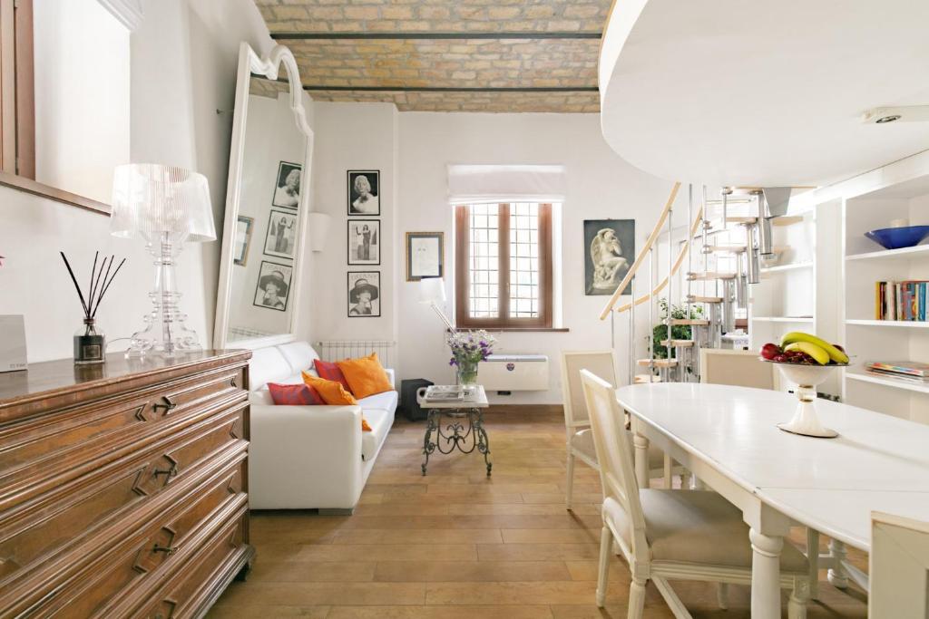 een keuken en eetkamer met een witte tafel en stoelen bij Leopardo 28 - Loft in Trastevere in Rome