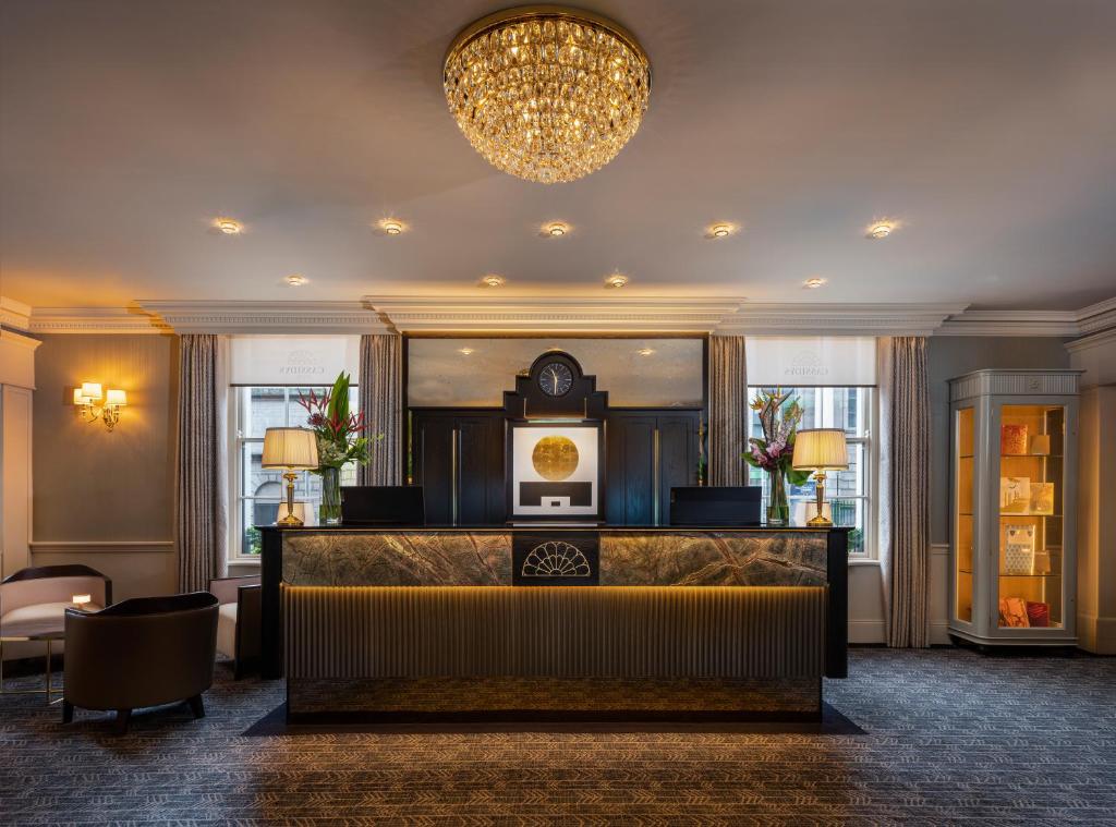 a hotel lobby with a reception desk and a chandelier at Cassidys Hotel in Dublin