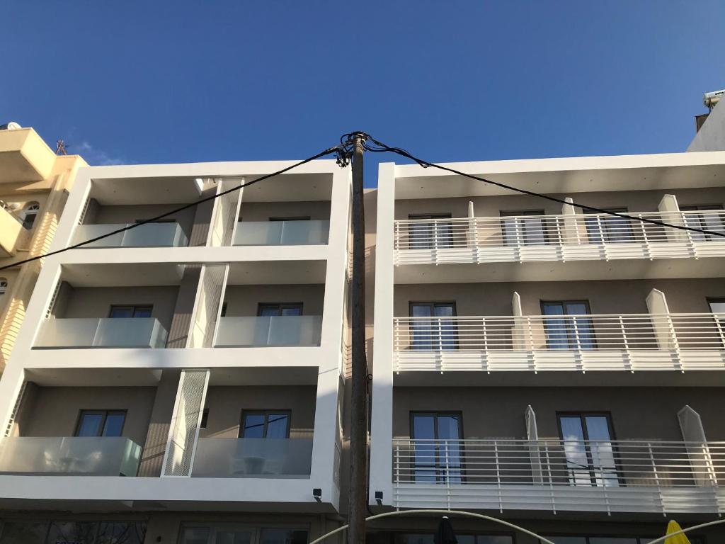 un edificio blanco con balcones en un lateral en Frini Hotel, en La Canea