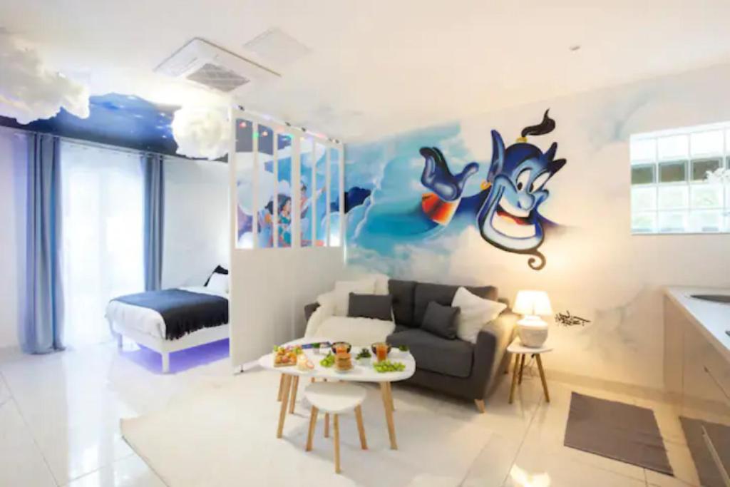ein Wohnzimmer mit einem Sofa und einem Tisch in der Unterkunft Suite Aladdin - 4P - Proche Disney in Montry