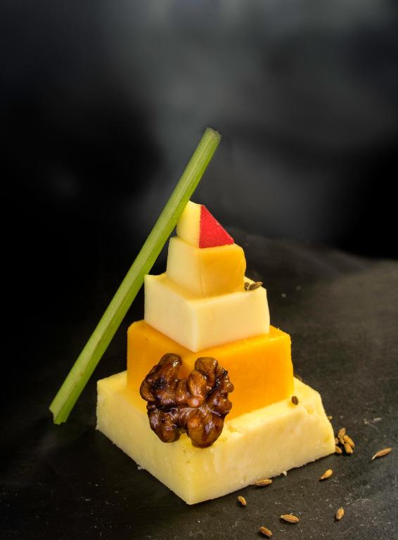 a piece of cheese with fruit on top of it at The Raintree, St. Mary’s Road in Chennai