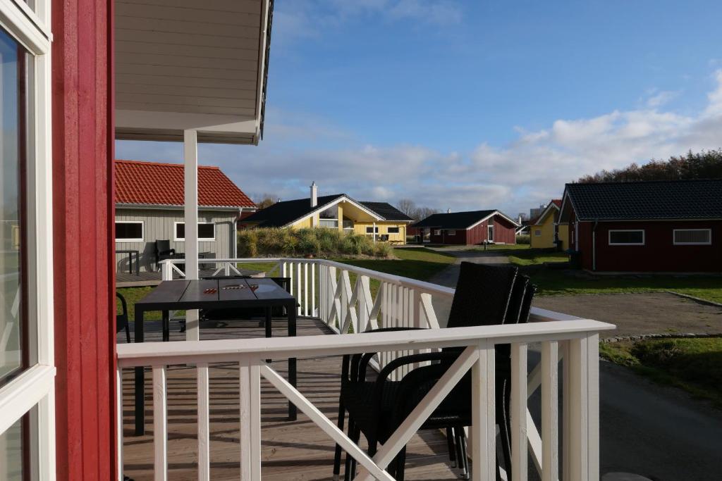 een balkon met een tafel, stoelen en huizen bij Resort 2 Ocean Cottage A 103 in Großenbrode