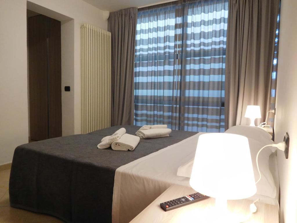 a hotel room with a bed with two towels on it at Gabbiano Apartments in Rimini