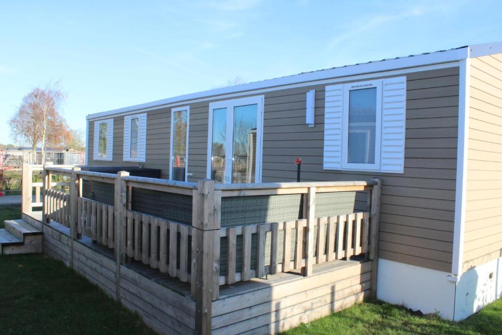 a mobile home with a large wooden deck at Siblu camping in de Bongerd in Oostkapelle