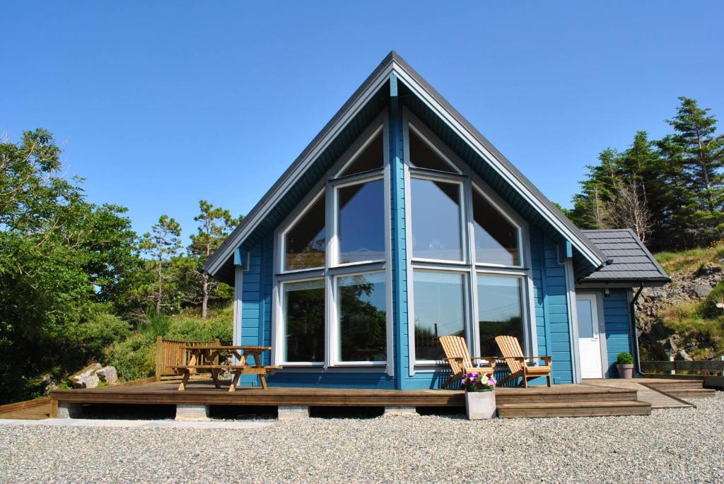 a blue house with two chairs and a table at The Hatchery in Tolstachaolais