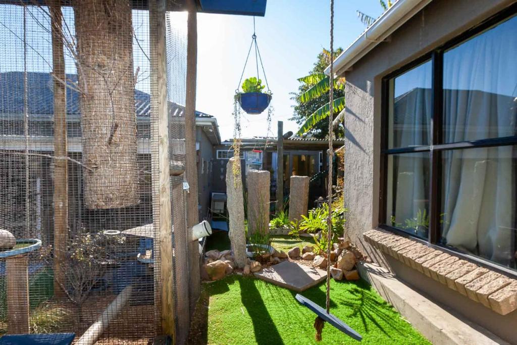 a bird cage with a swing in a yard at Penguin - Double En-Suite Studio in Cape Town