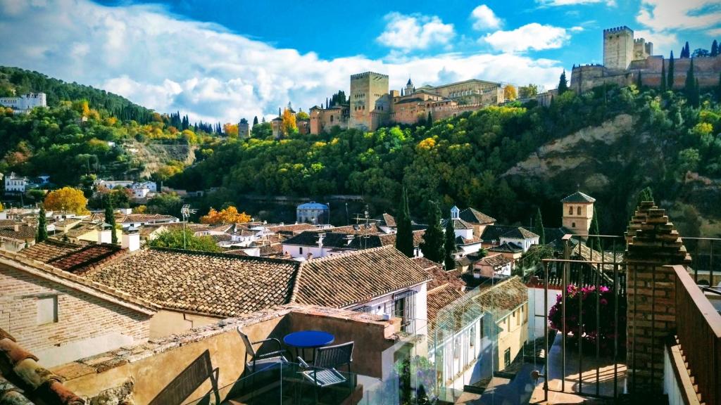 vista su una città con edifici e una montagna di Apartamentos Alhambra a Granada