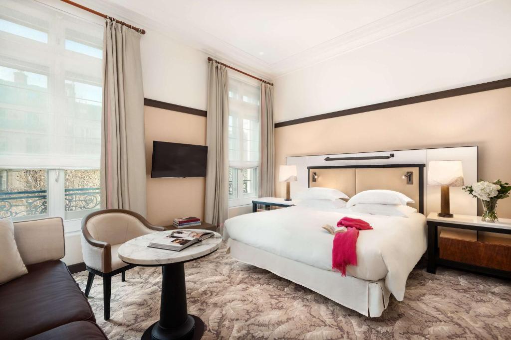 a hotel room with a large bed and a large window at Hyatt Paris Madeleine in Paris