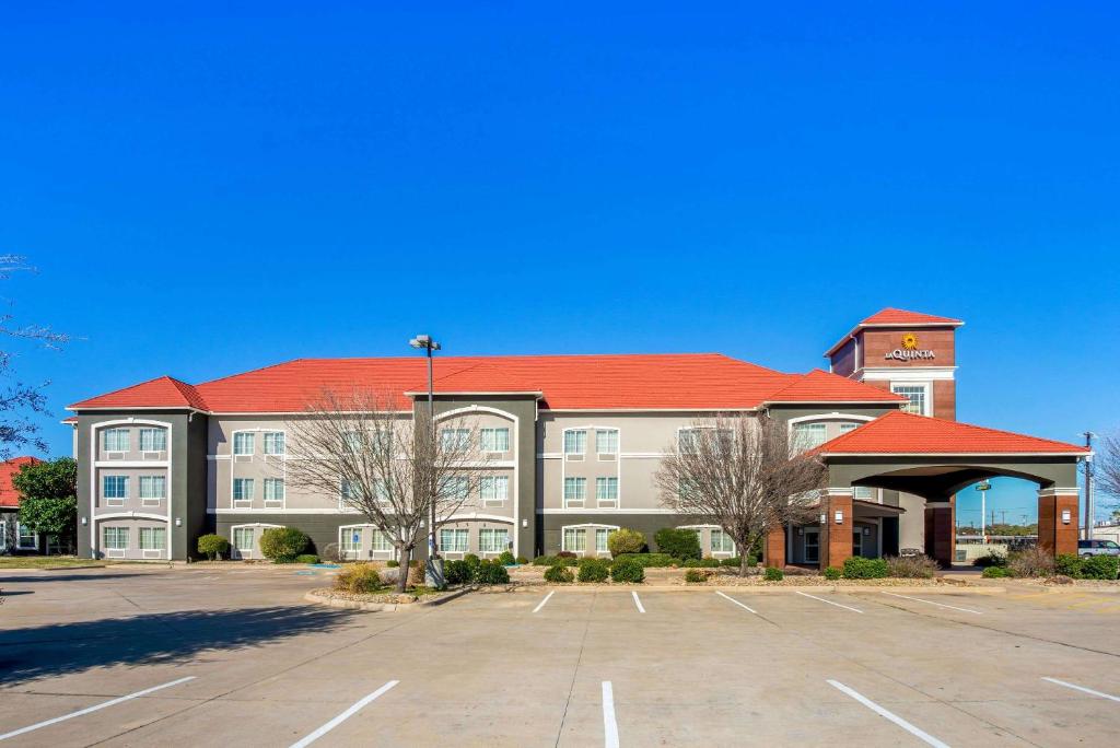 a large building with a parking lot in front of it at La Quinta by Wyndham Eastland in Eastland