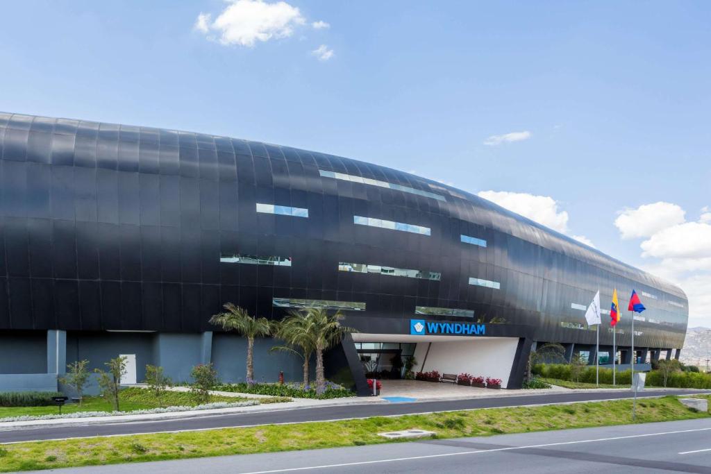 a large black building with a road in front of it at Wyndham Quito Airport in Tababela