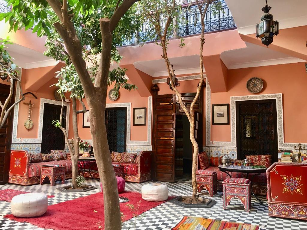 un vestíbulo con muebles rojos y un árbol en Riad Blue Berber, en Marrakech