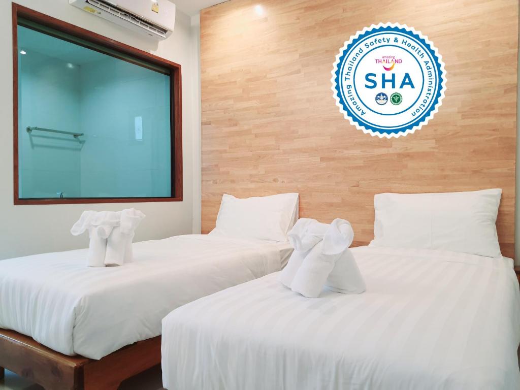 two beds in a room with a large screen at SUhotel Suratthani in Surat Thani