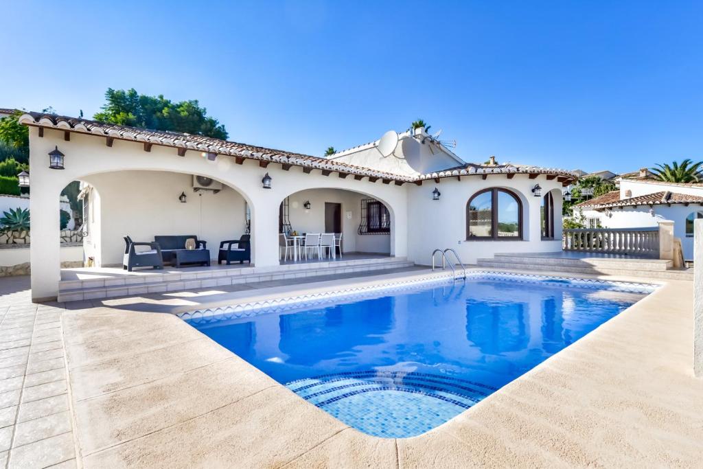 a villa with a swimming pool in front of a house at Villas Guzman - Erita in Benissa