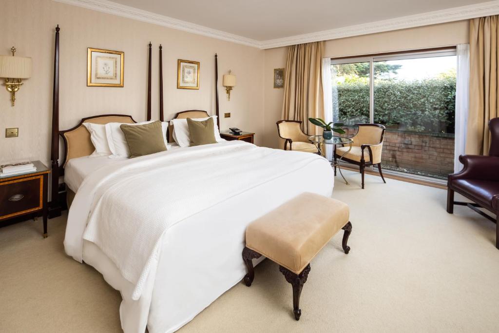 a large bedroom with a large white bed and a table at The Atlantic Hotel - Small Luxury Hotels of the World in St Brelade