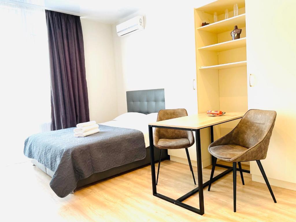 a bedroom with a bed and a desk and chairs at Mira Apart-Hotel in Kyiv
