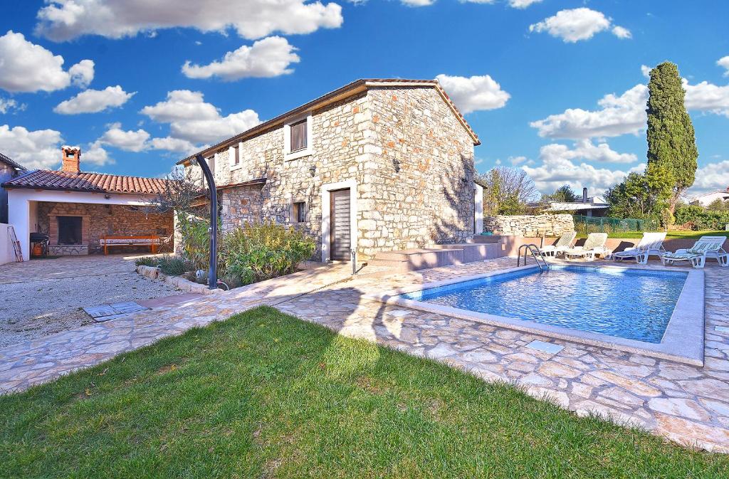 ein Steinhaus mit einem Pool davor in der Unterkunft Casa Isabella in Galižana