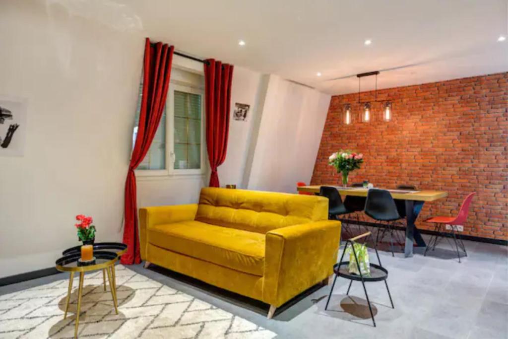 een woonkamer met een gele bank en een tafel bij Suite Brooklyn - 6P - Proche Disney in Montry