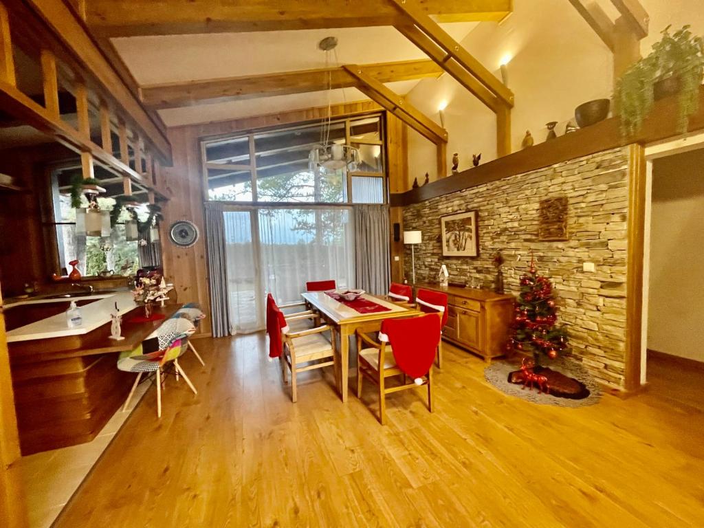 a kitchen and dining room with a table and red chairs at Pirin Golf Villa Emila in Bansko