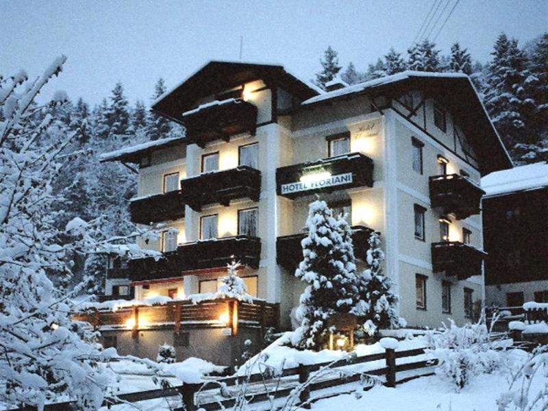 a large building with lights in the snow at Hotel garni Floriani in Berchtesgaden