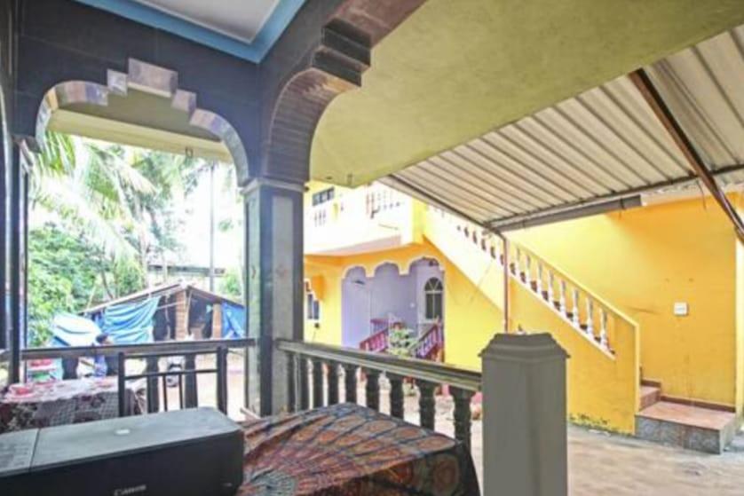 un balcón de una casa de color amarillo y morado en Radhabai Hotel, en Arambol