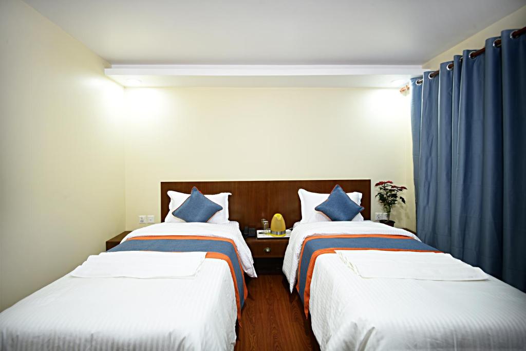A bed or beds in a room at Karma Hotel Nepal