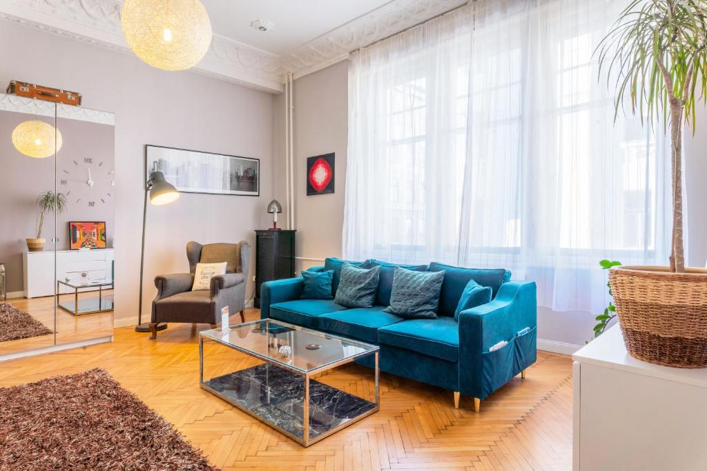 uma sala de estar com um sofá azul e uma mesa em SLEEP'N Budapest - free airport transfer em Budapeste