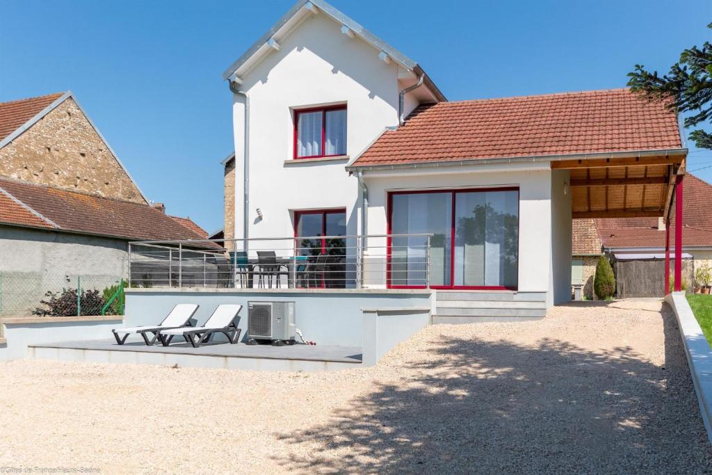 a white house with two lounge chairs in front of it at Les Bords de Saône in Rigny