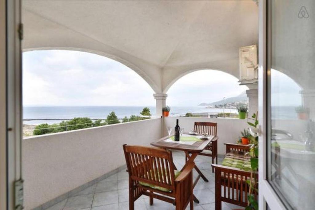 uma varanda com mesa e cadeiras e vista para o oceano em Apartment in Duce with sea view, terrace, air conditioning, WiFi 5063-1 em Duće