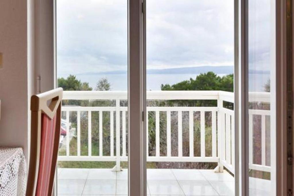 una puerta corredera de cristal con vistas a un balcón en Apartment in Duce with sea view, balcony, air conditioning, WiFi 5063-2 en Duće