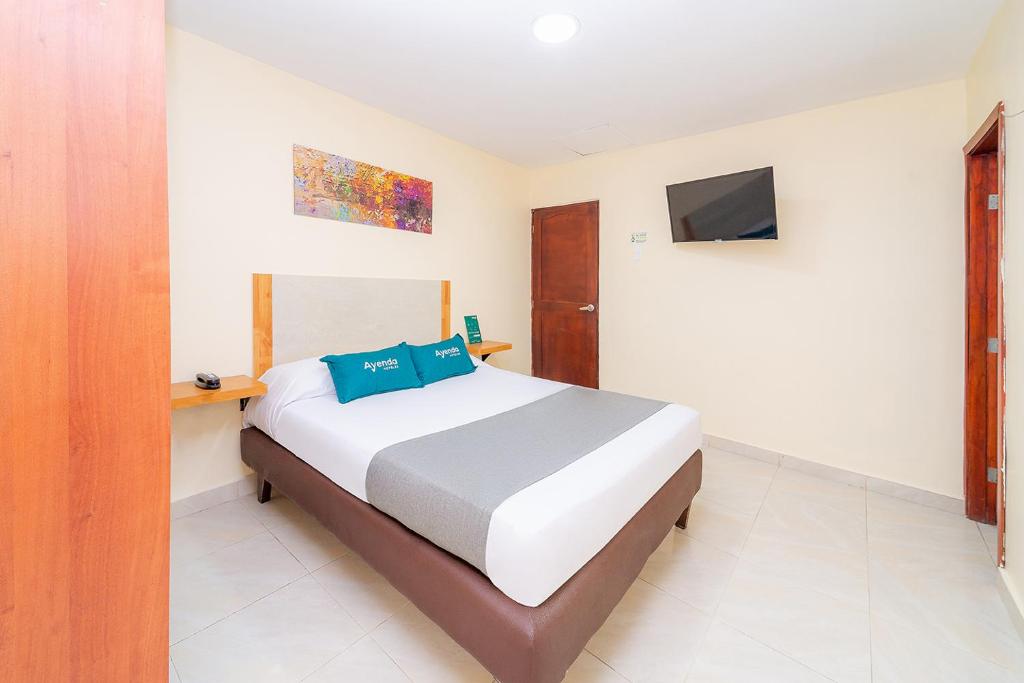 a bedroom with a bed and a tv on the wall at Ayenda Baly Express in Malambo
