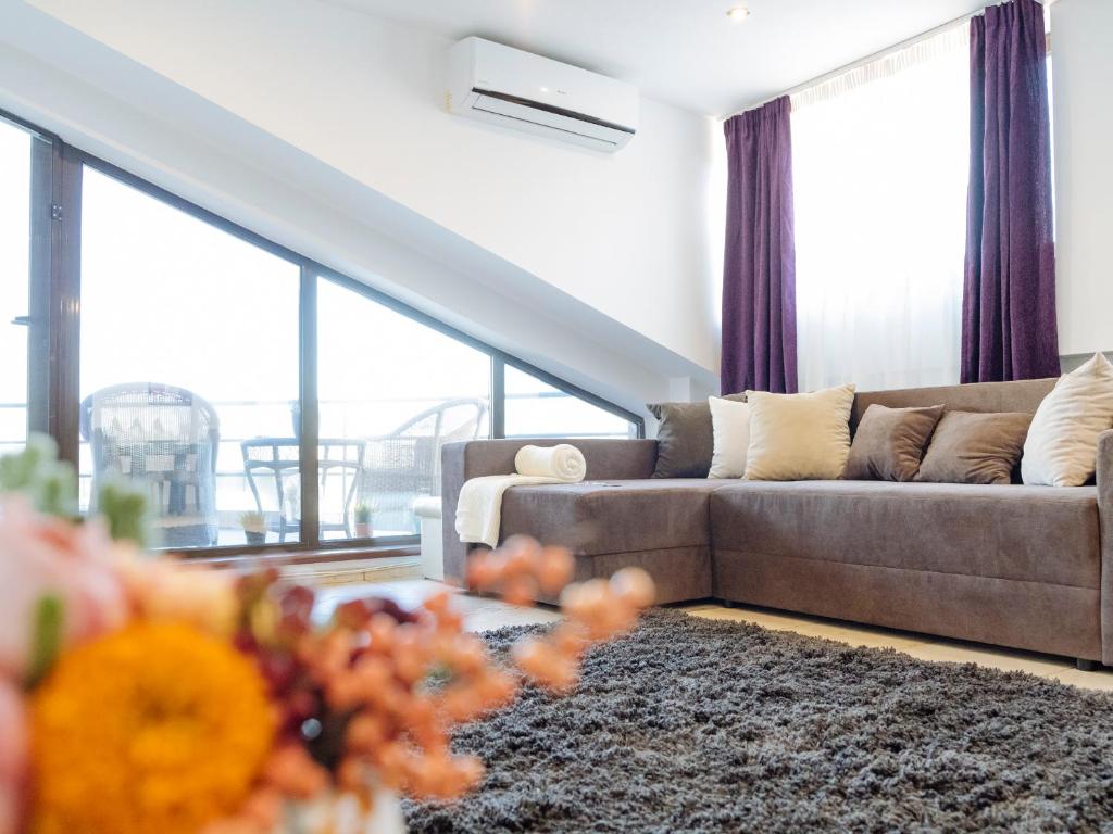 a living room with a couch and a large window at Penthouse with stunning view over the city and large terrace in Bucharest