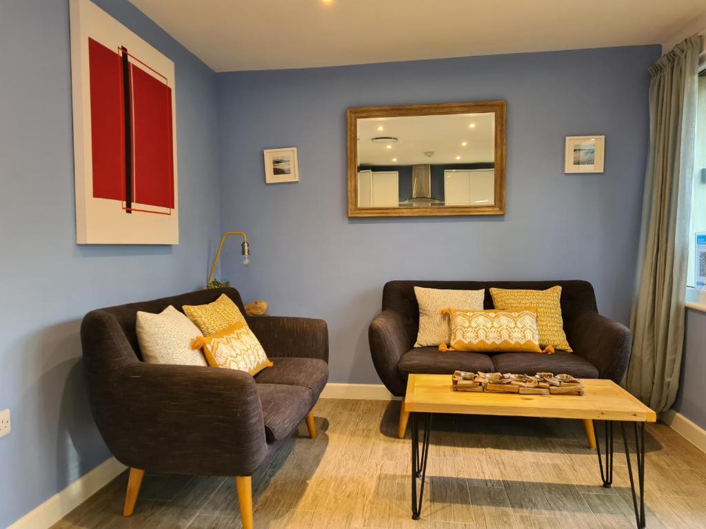 a living room with two couches and a coffee table at Pebble Cottage in Uny Lelant