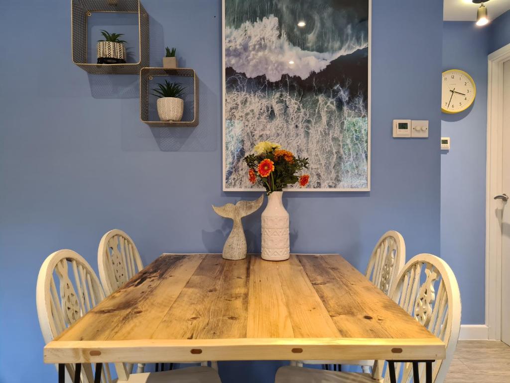 a dining room with a wooden table and chairs at Pebble Cottage in Uny Lelant