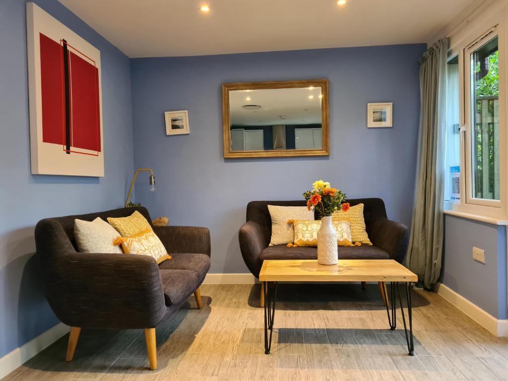 a living room with a couch and a table at Pebble Cottage in Uny Lelant