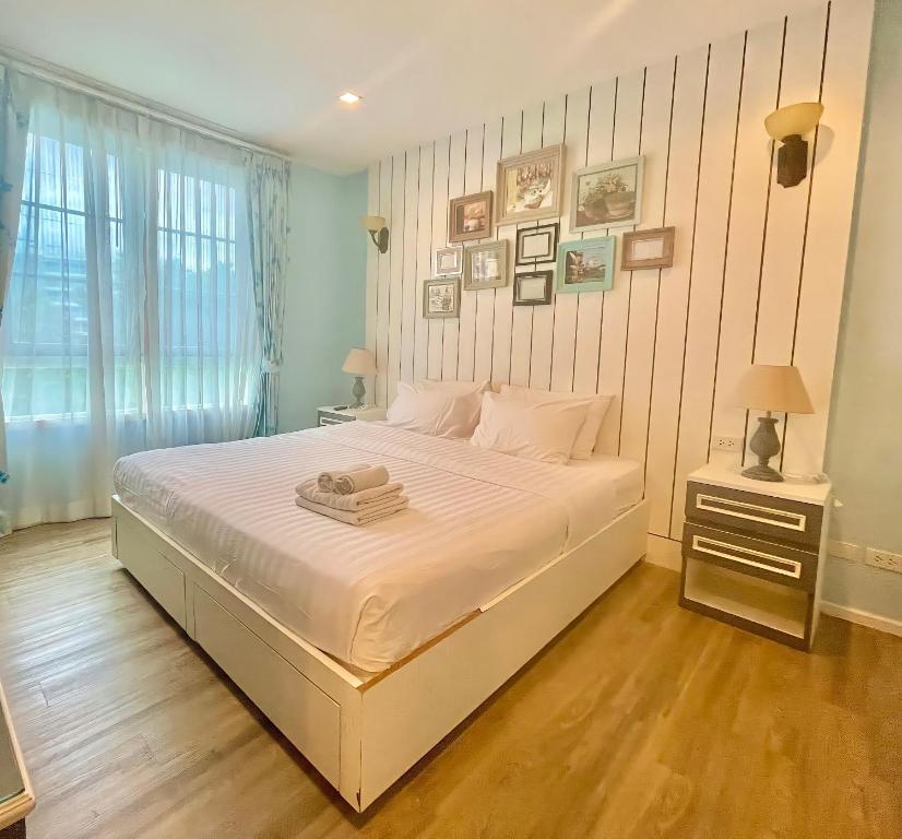 Un dormitorio con una gran cama blanca y una ventana en Summer Huahin Condo 2 Bedrooms Pool View Classic Room, en Hua Hin