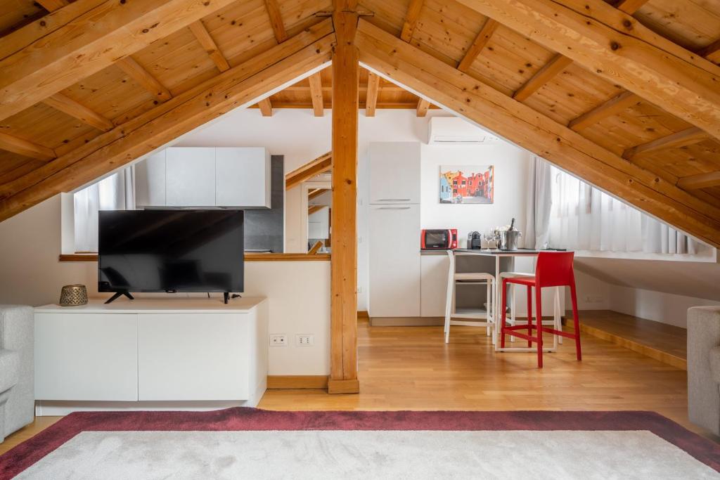 eine Küche und ein Wohnzimmer mit weißen Schränken und einem Flachbild-TV in der Unterkunft Biennale Palace R&R in Venedig