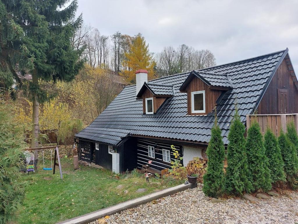 dom z czarnym dachem na wzgórzu w obiekcie Roubenka u potoka Výprachtice w mieście Výprachtice