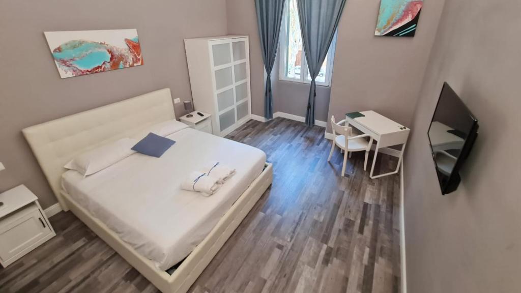 een slaapkamer met een bed, een bureau en een televisie bij San Peter Vale House in Rome
