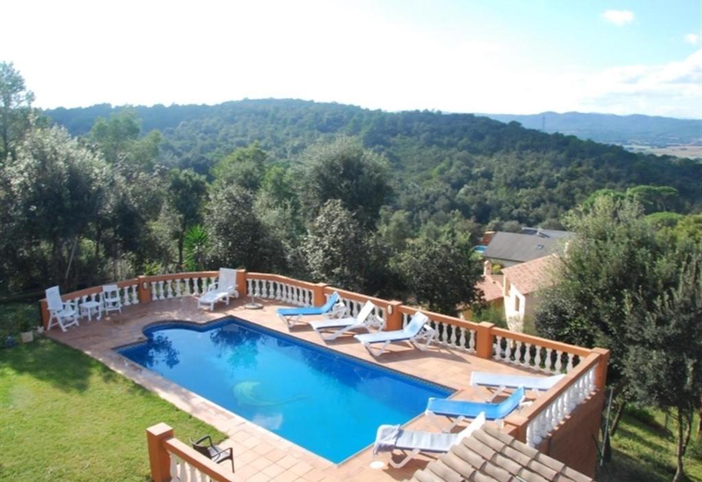 a large swimming pool with chairs and a deck at Villa Casa Dolores Style Catalan in Begur