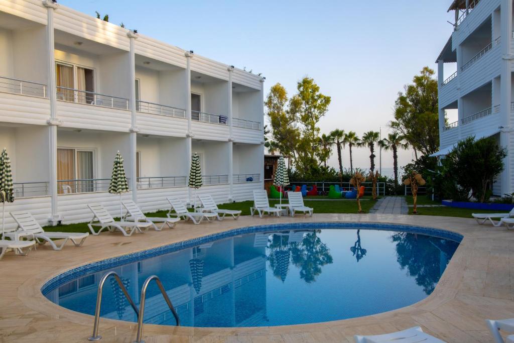 a hotel with a swimming pool in front of a building at Aroma Butik Hotel in Kızılot