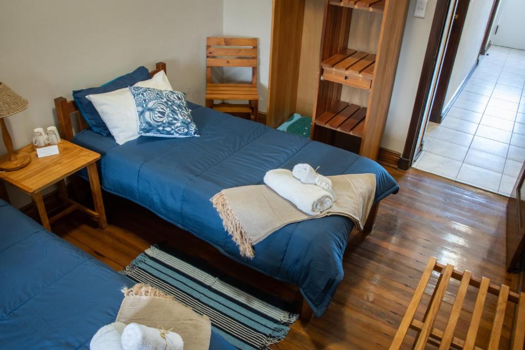 a bedroom with a blue bed with towels on it at The Mole Guesthouse in Swakopmund