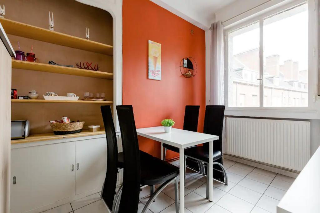 a kitchen with a table and chairs in a room at Apt Chic, 60m2, 2 Chambres, Centre in Valenciennes
