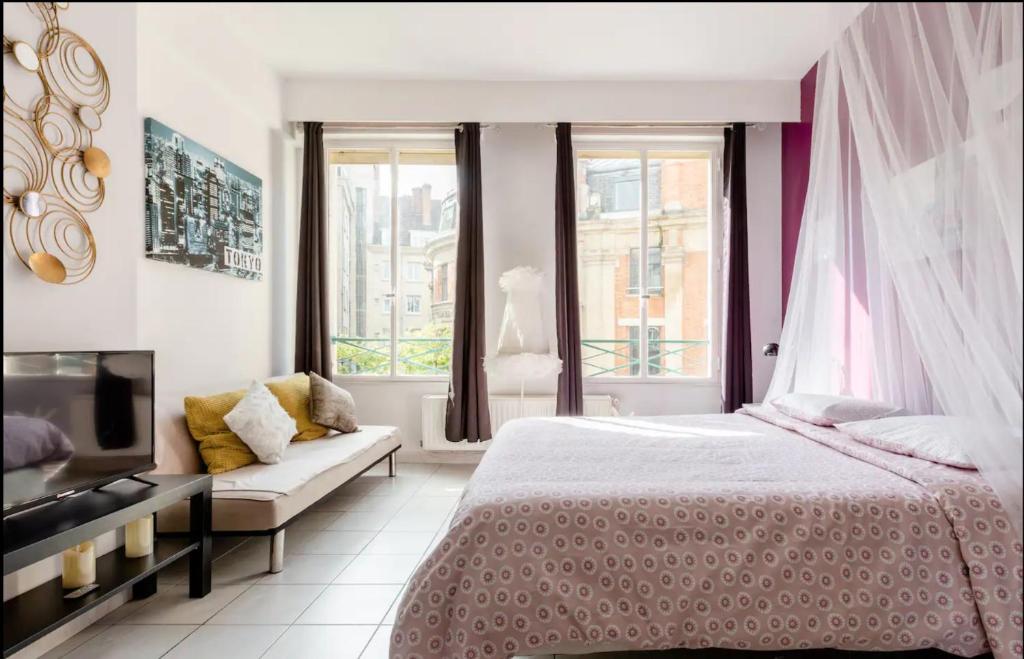 a bedroom with a bed and a couch and windows at Apt Chic, 60m2, 2 Chambres, Centre in Valenciennes