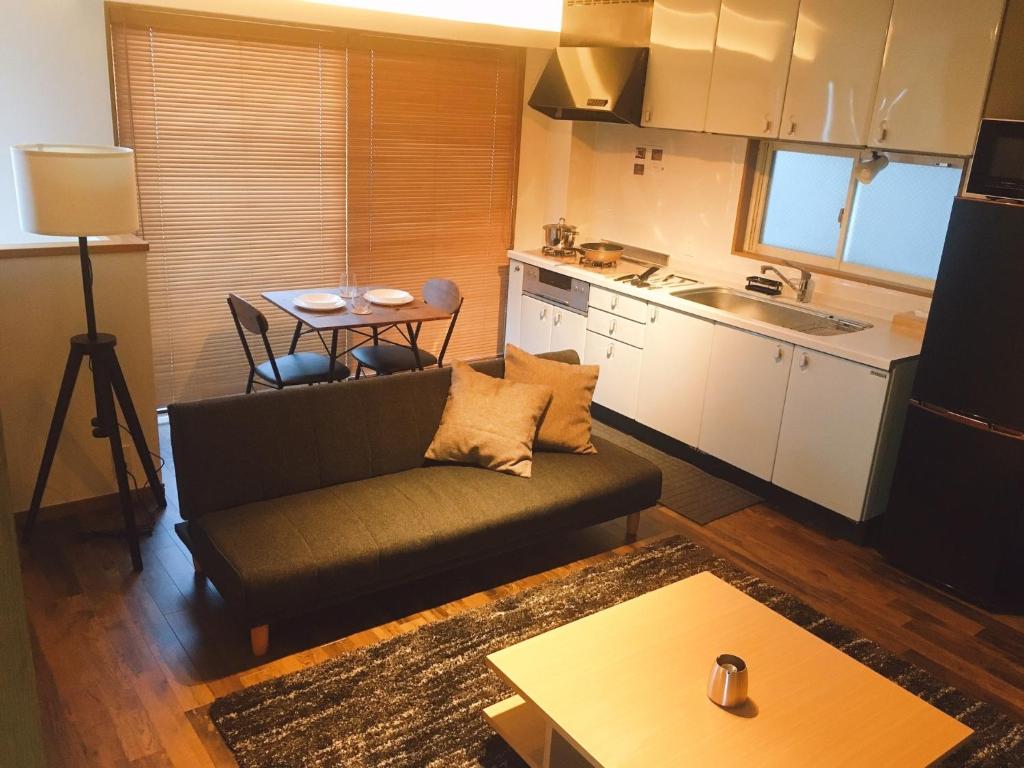 東京にあるChill Inn Honan - Vacation STAY 94561vのリビングルーム(ソファ、テーブル付)、キッチンが備わります。