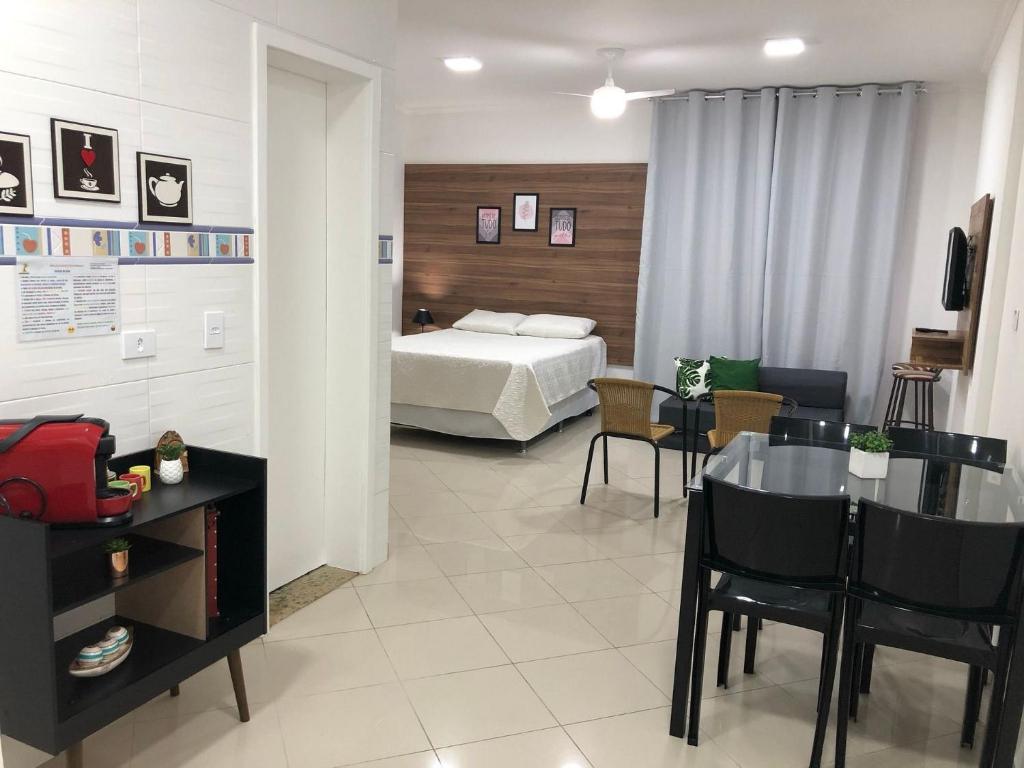 a hotel room with a bed and a table and chairs at Estúdio charmoso um minuto a pé do mar in Guarujá