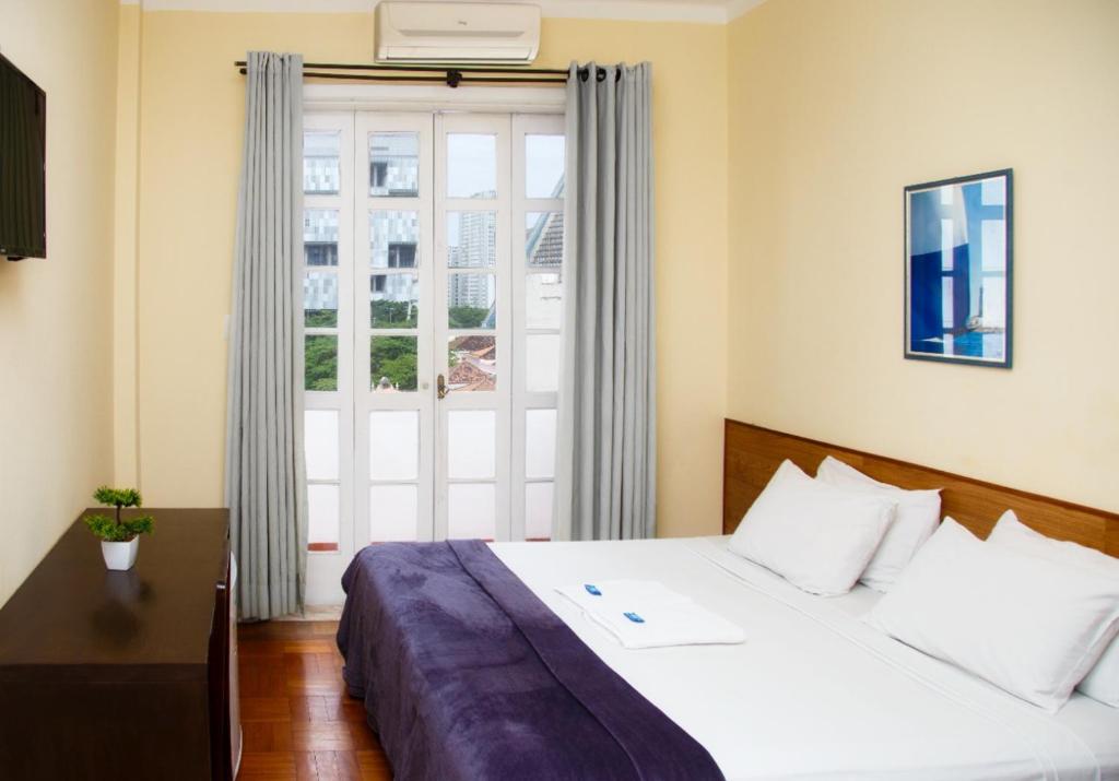 a bedroom with a large bed and a window at Hotel Carioca in Rio de Janeiro