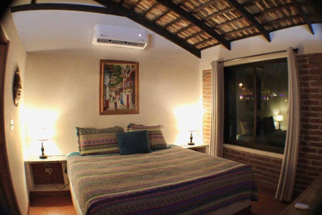 - une chambre avec un lit, deux lampes et une fenêtre dans l'établissement Sukasa Bungalows, à Loreto